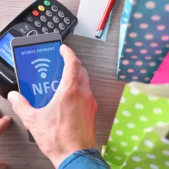 Zbliżasz telefon z widocznym napisem NFC do terminala płatniczego. To mobilna płatność, szybka i wygodna.