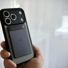 Dłoń trzyma telefon z naklejonym modułem, który może służyć jako dyktafon w telefonie.