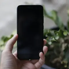 Dłoń trzyma czarny iPhone. Chcesz wiedzieć, jak wyłączyć iPhone?