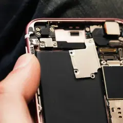 Wymiana baterii w iPhone 11: widok wnętrza telefonu z dużą czarną baterią.