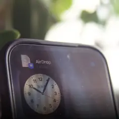 Szybki udostępnianie wideo przez AirDrop. Na ekranie telefonu widoczny jest zegar.