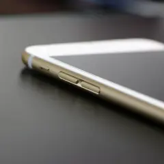 Złoty iPhone leży na ciemnym blacie. Wiesz, jak znaleźć iPhone, gdy go zgubisz?