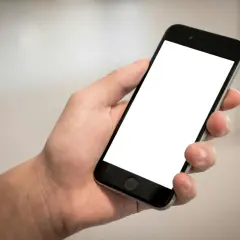 Dłoń trzyma smartfon z pustym ekranem. Cisza, brak id dzwoniącego.