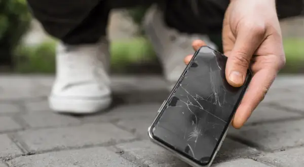 Zepsuty telefon z pękniętą szybką. Zastanawiasz się, ile kosztuje wymiana szybki w telefonie?