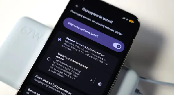 Telefon z włączonym trybem oszczędzania baterii, obok ładowarki 67W. Funkcja "always on display" nie jest widoczna.