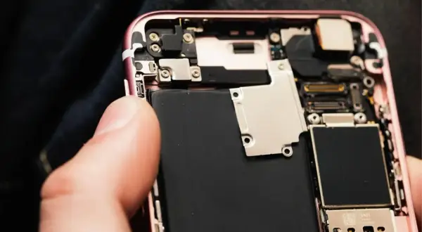 Wymiana baterii w iPhone 11: widok wnętrza telefonu z dużą czarną baterią.