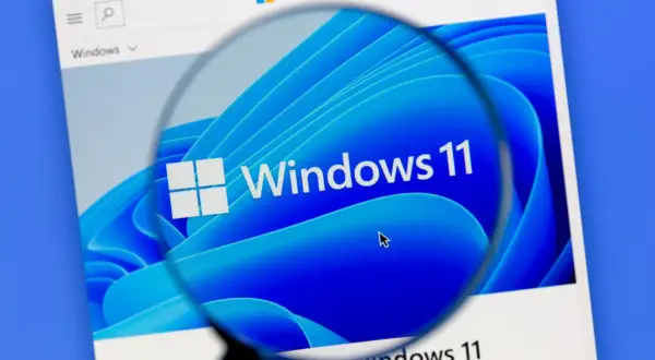 Lupa powiększa logo Windows 11, sugerując rozwiązanie problemu z wolnym komputerem.