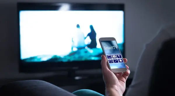 Smartfon steruje telewizorem przez Wi-Fi, wyświetlając obraz z telefonu na TV.
