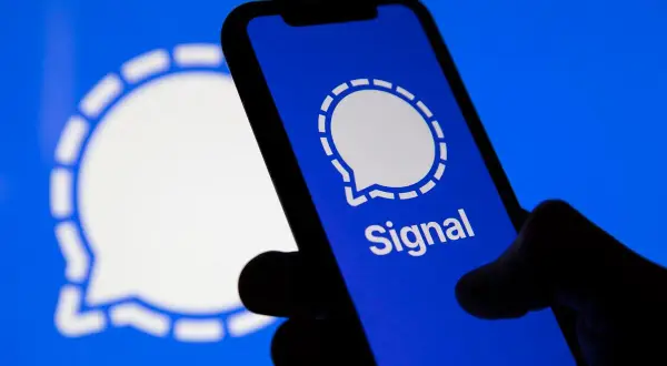 Dłoń trzyma smartfon z otwartą aplikacją Signal, popularnym komunikator.