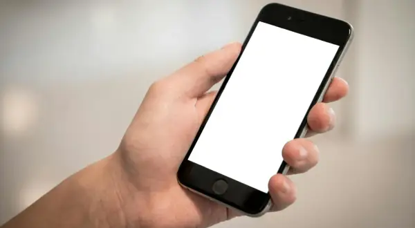 Dłoń trzyma smartfon z pustym ekranem. Cisza, brak id dzwoniącego.