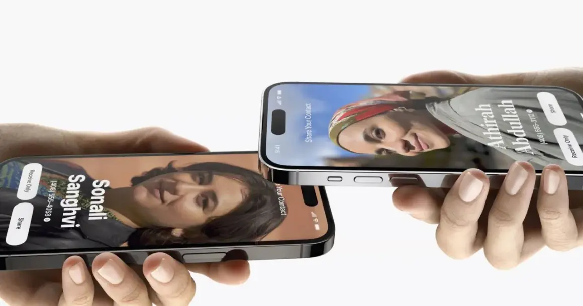 Dwie dłonie trzymają iPhone'y z funkcją udostępniania kontaktów w iOS 17. Na ekranach widnieją zdjęcia i dane Sonali Sanghvi oraz Athirah Abdullah.