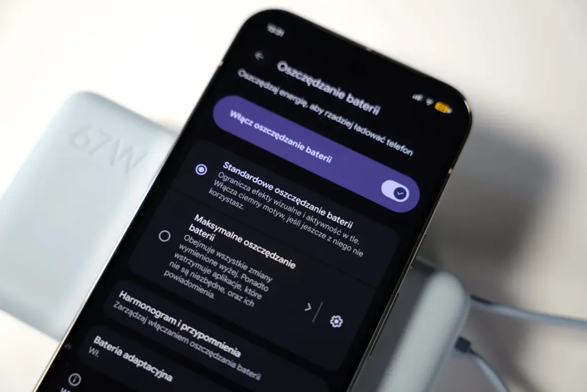 Telefon z włączonym trybem oszczędzania baterii, obok ładowarki 67W. Funkcja "always on display" nie jest widoczna.