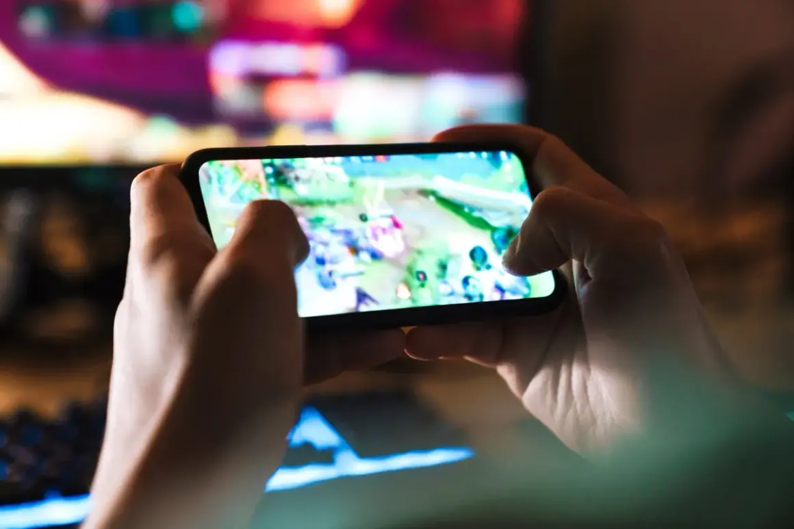 Dłonie trzymają smartfon z grą. Szybkość 5G co to? To płynna rozgrywka mobilna bez lagów, idealna do gier online.