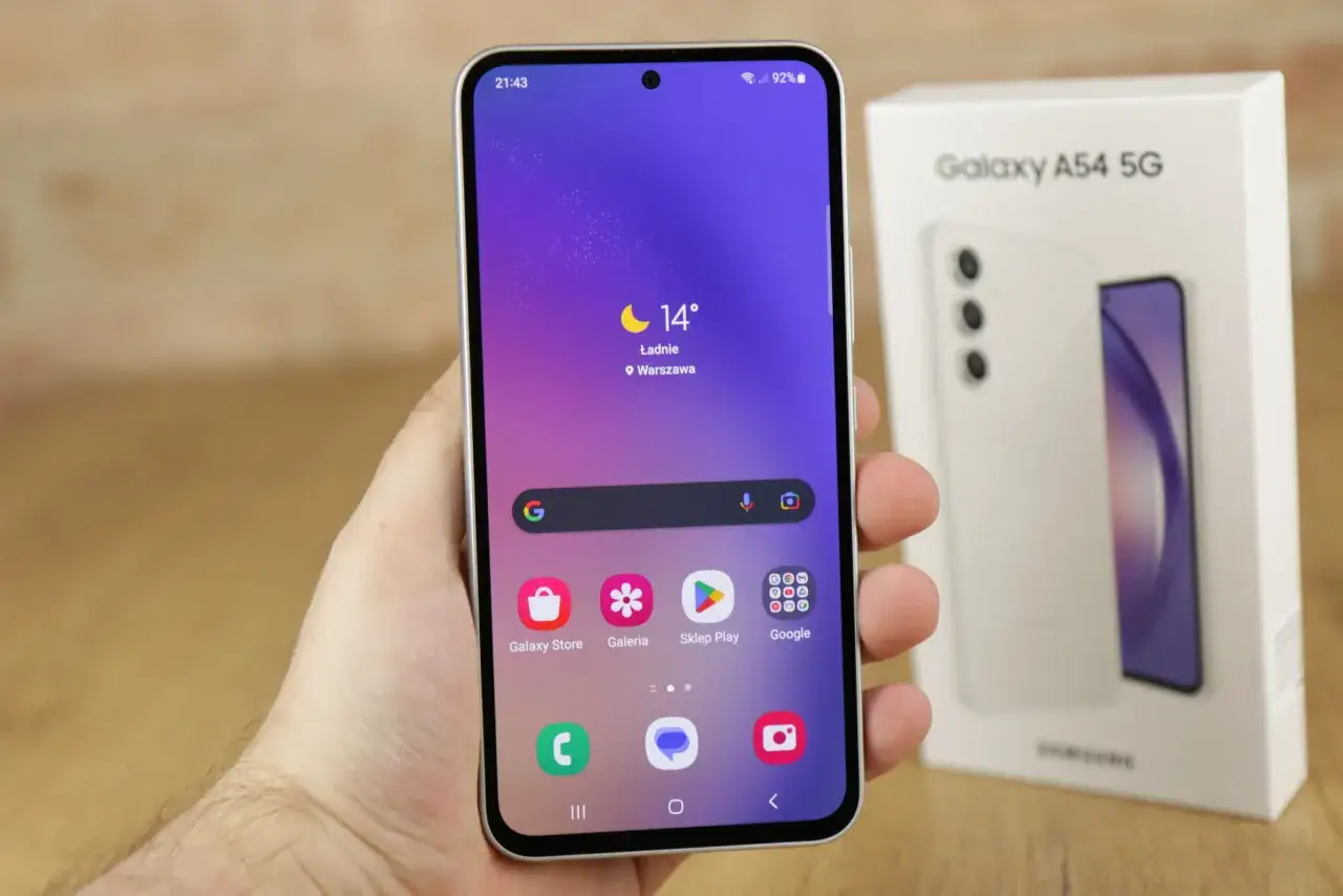 Szukasz telefonu do 1500? Samsung Galaxy A54 5G na zdjęciu prezentuje się świetnie, z ekranem i pudełkiem.