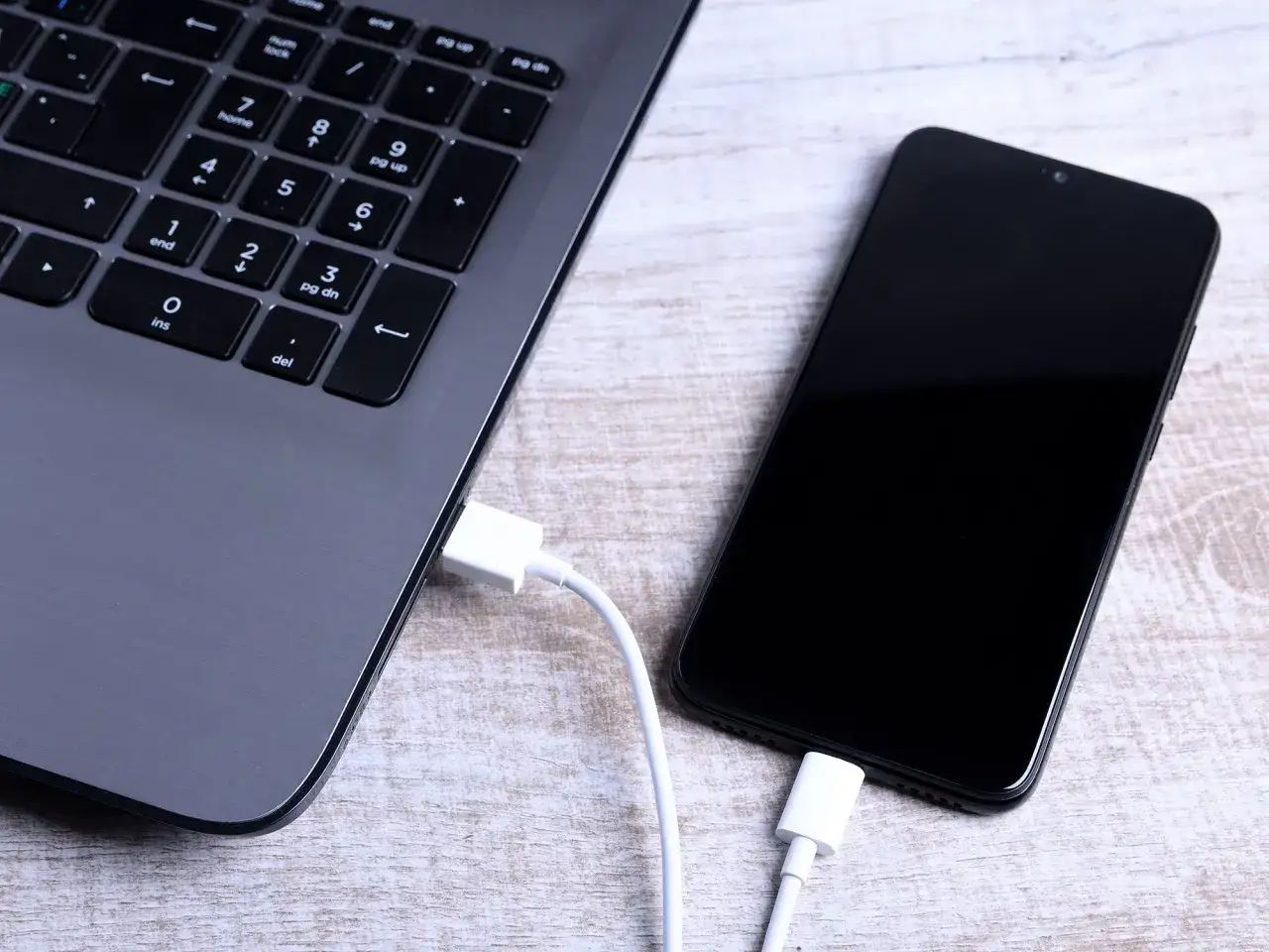 Łączenie telefonu z laptopem kablem USB to prosty sposób, jak przesłać zdjęcia z telefonu na komputer.