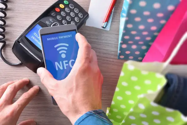 Zbliżasz telefon z widocznym napisem NFC do terminala płatniczego. To mobilna płatność, szybka i wygodna.