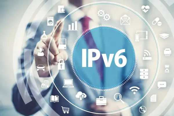Człowiek dotyka ekranu z napisem IPv6, otoczonego ikonami symbolizującymi różne technologie i usługi, od samochodów po chmurę.
