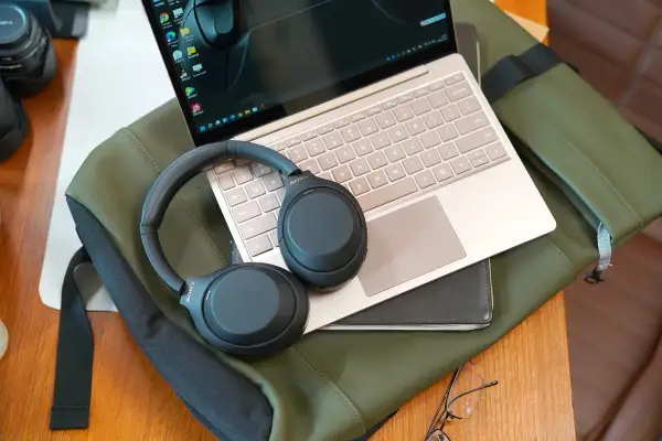 Słuchawki Sony na laptopie, gotowe do sparowania z telefonem. Idealny zestaw do pracy i podróży.