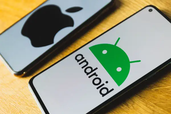 Dwa telefony: jeden z logo Androida, drugi z logo Apple. Dowiedz się, jak przenieść dane z Androida na iPhone.