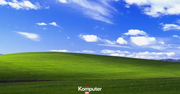 Zielone wzgórze pod błękitnym niebem z białymi chmurami, ikoniczny krajobraz z **Windows XP**.